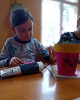 zdjęcie dziecka malującego doniczkę