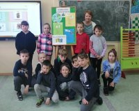 grupowe zdjęcie bibliotekarki i dzieci z tablicą edukacyjną