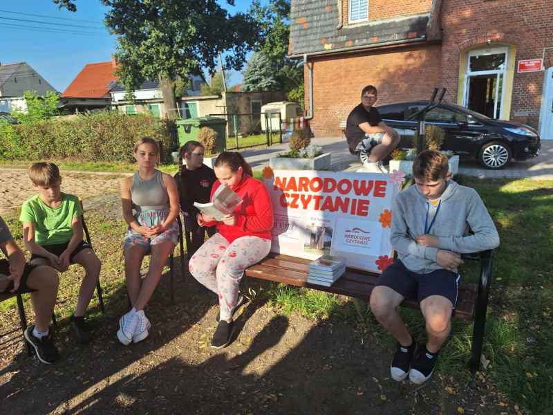 zdjęcie uczniów w trakcie lektury książki na ławce