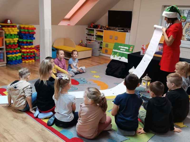 zdjęcie bibliotekarki rozwijającej długa listę prezentów świątecznych