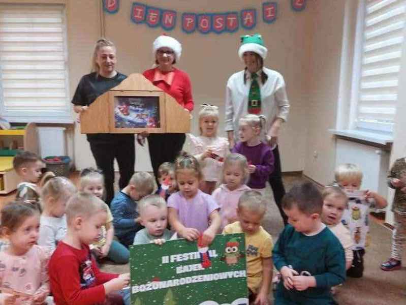 zdjęcie bibliotekarek i wychowawczyni grupy trzymających teatrzyk kamishibai oraz grupa dzieci z przodu z plakatem projektu