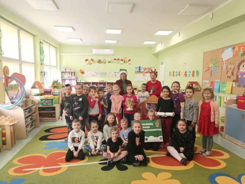 wspólne zdjęcie bibliotekarek i dzieci z teatrzykiem i plakatem festiwalu