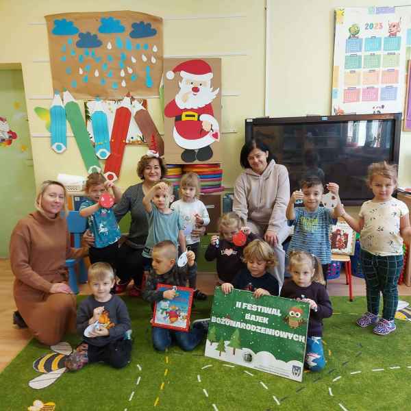 wspólne zdjęcie bibliotekarki, wychowawczyń i dzieci z książką i  plakatem festiwalu