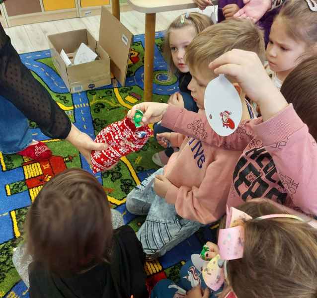 zdjęcie dzieci częstujących się cukierkami od bibliotekarki