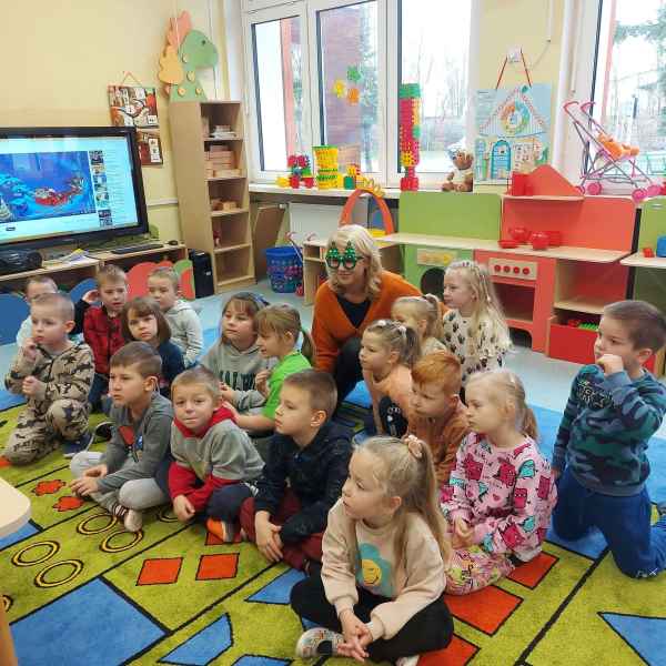 zdjęcie grupy przedszkolnej i wychowawczyni oglądających spektakl