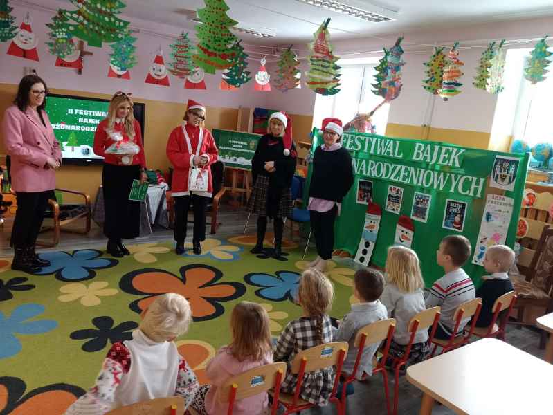 zdjęcie wiceburmistrz, z dyrektor biblioteki, bibliotekarek i kadry szkoły przed dziećmi