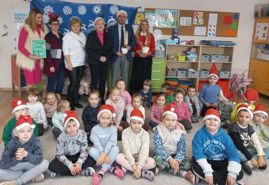 zdjęcie dzieci z przodu oraz burmistrza, bibliotekarki, dyrektor biblioteki i nauczycielek