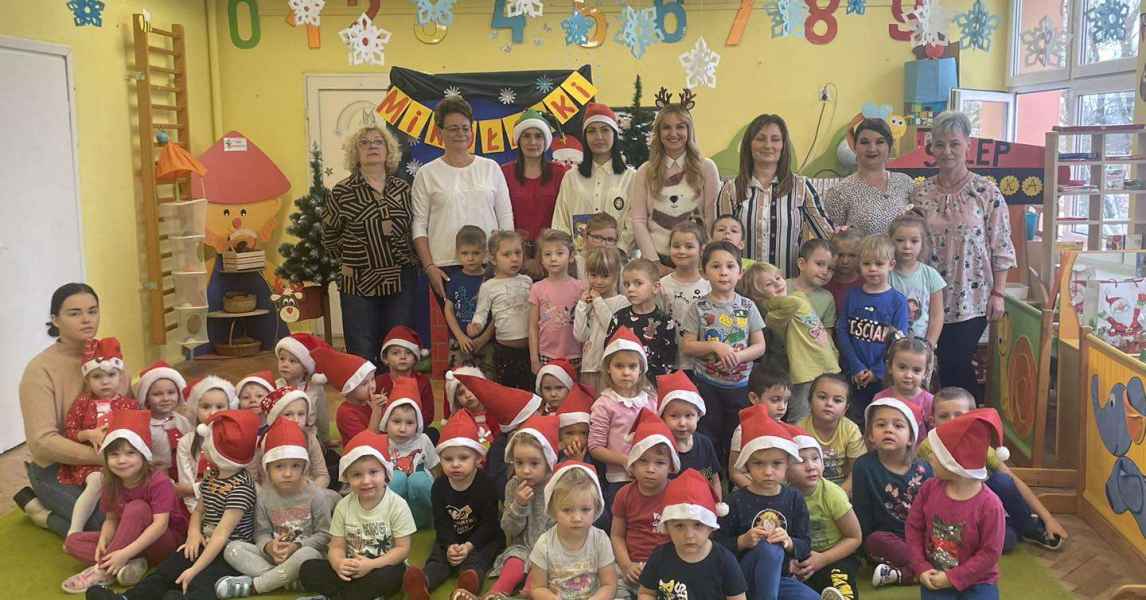 zdjęcie grupowe pracowników biblioteki i przedszkola, przed nimi dzieci