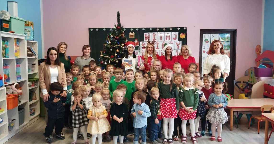 zdjęcie pracowników przedszkola i biblioteki z dziećmi