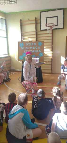 zdjęcie bibliotekarki badającej stetoskopem lalkę w wózku