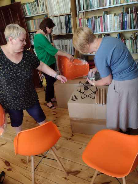 zdjęcie pracowników biblioteki skręcających krzesła