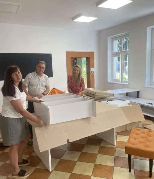 zdjęcie pracowników biblioteki skręcających regał