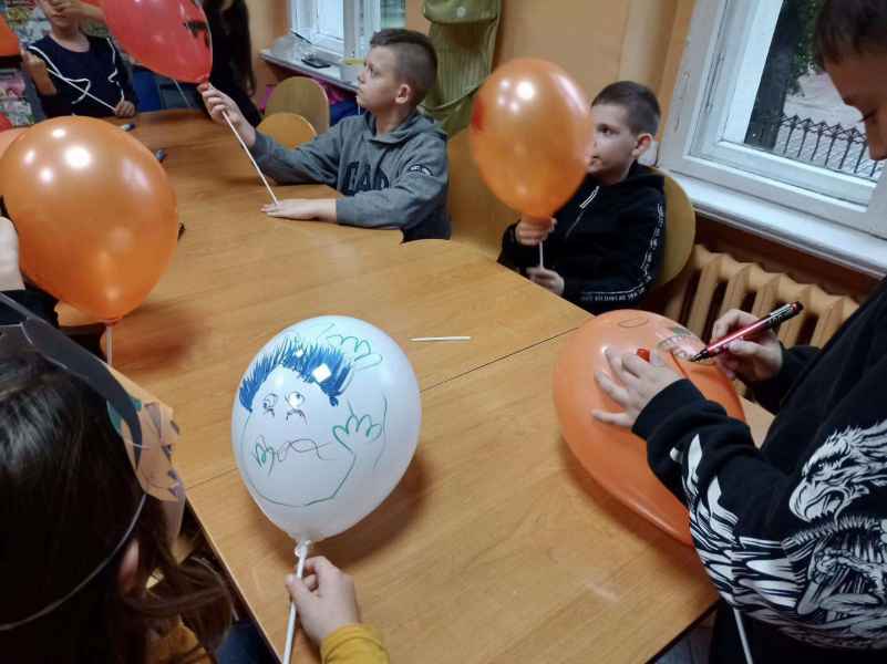 zdjęcie dzieci malujących twarze na balonach