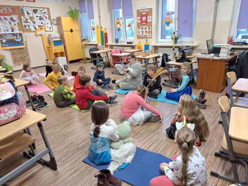 zdjęcie bibliotekarki czytającej dzieciom zagadki