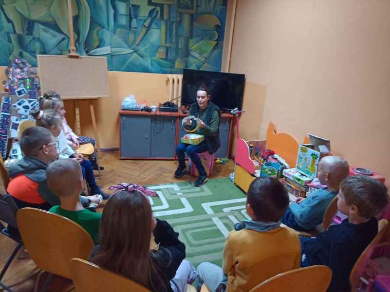 zdjęcie bibliotekarki grającej w grę zgadnij kto to z dziećmi