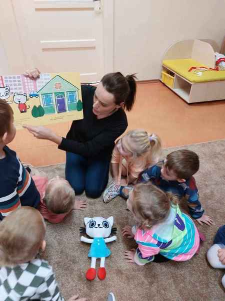 zdjęcie bibliotekarki czytającej przedszkolakom książeczkę kicia kocia i nunuś - bardzo fajna rodzina