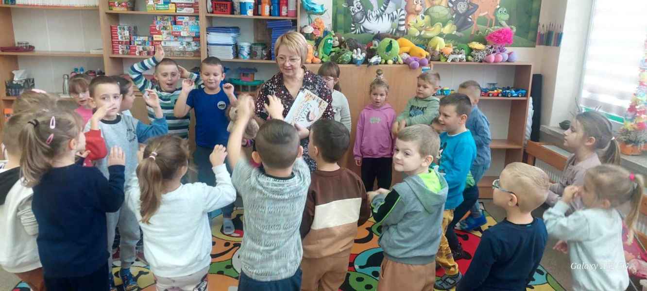 zdjęcie bibliotekarki otoczonej przez przedszkolaków