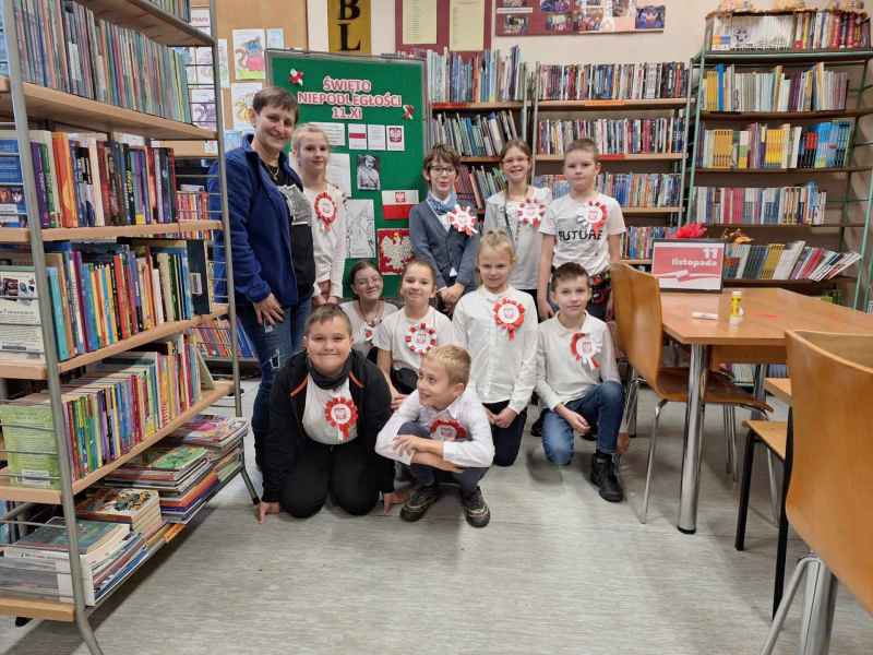 grupowe zdjęcie bibliotekarki oraz dzieci z własnoręcznie wykonanymi kotylionami