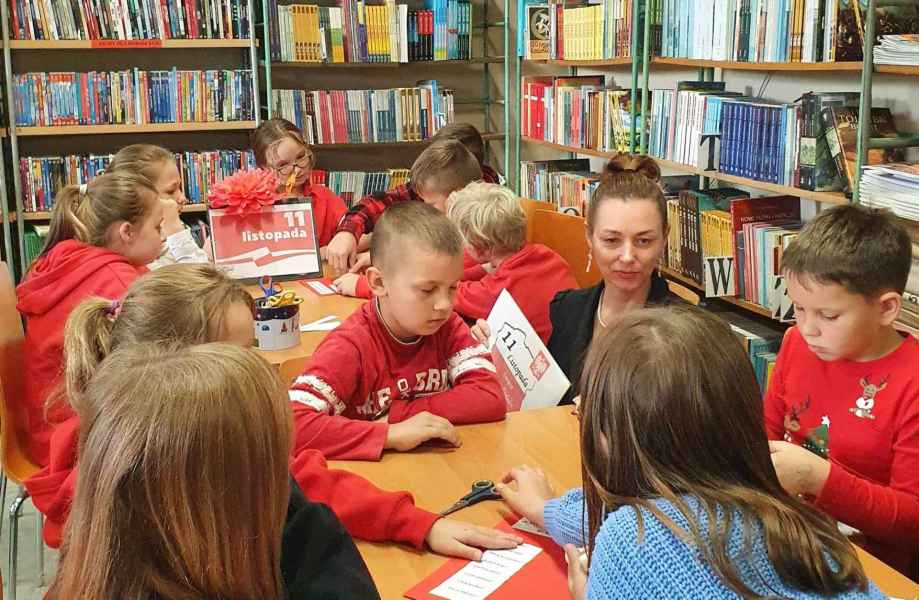 zdjęcie dzieci oraz wychowawczyni przy stolikach