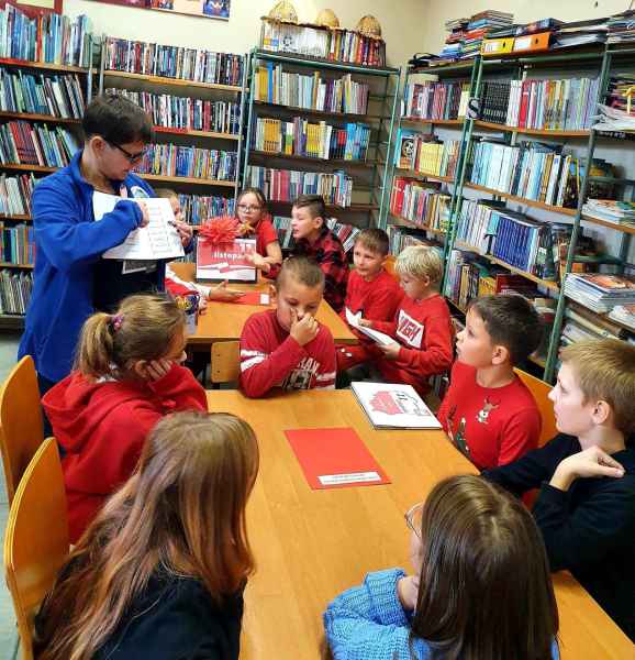 zdjęcie bibliotekarki czytającej dzieciom książkę