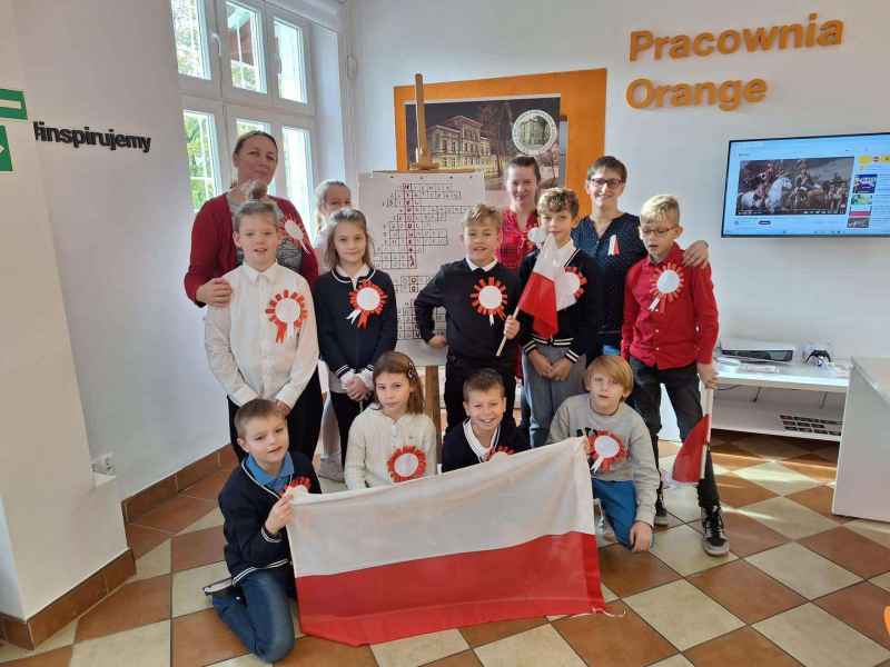 zdjęcie wychowawczyń i bibliotekarek pozujących z dziećmi trzymającymi flagą i z przyczepionymi kotylionami