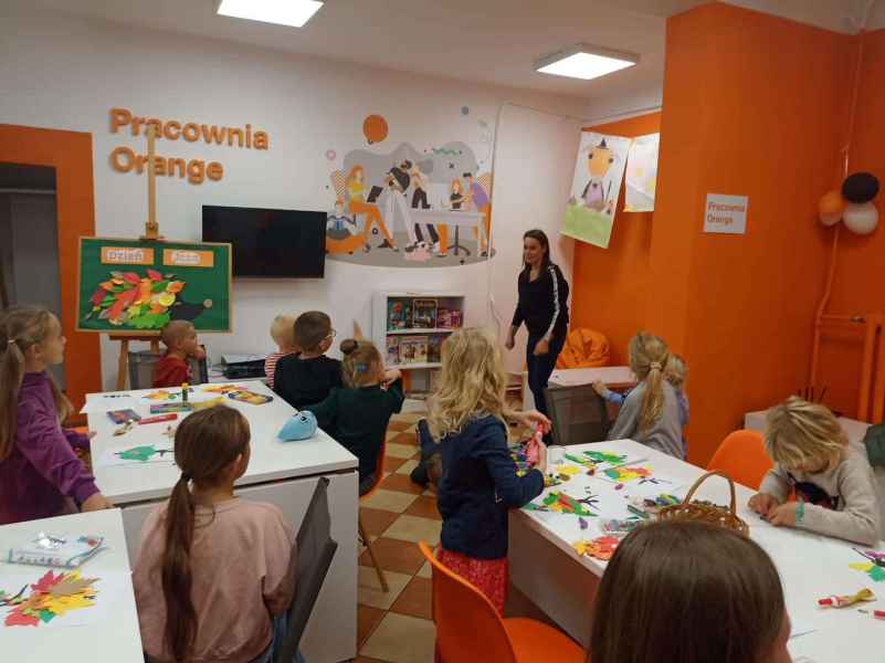 zdjęcie bibliotekarki tłumaczącej dzieciom zadanie