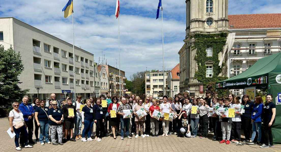grupowe zdjęcie wszystkich uczestników oraz pracowników biblioteki na placu przed ratuszem