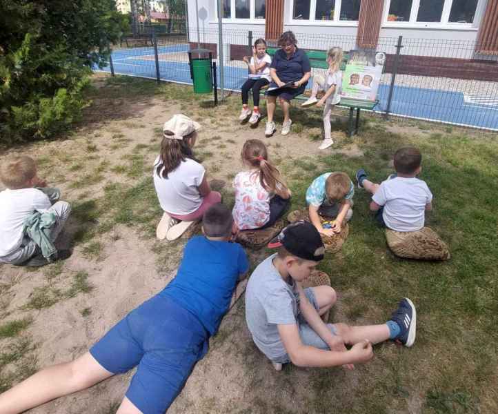 zdjęcie dzieci podczas słuchania czytanej przez bibliotekarkę książki