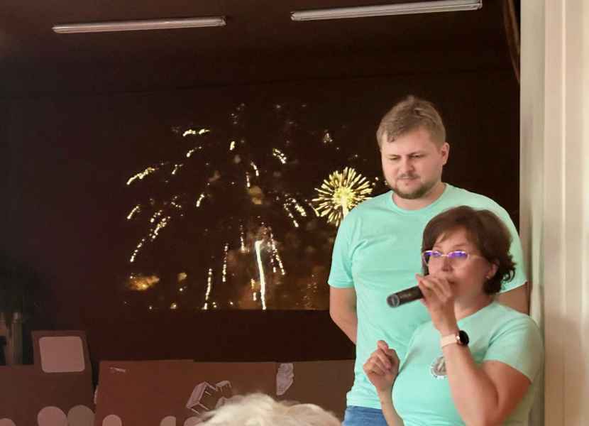 zdjęcie bibliotekarki i informatyka na tle slajdu z fajerwerkami