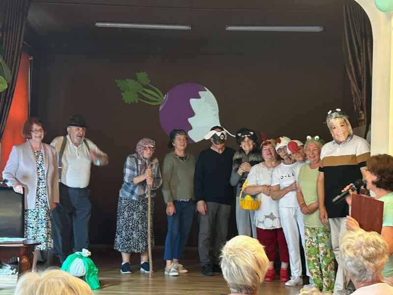 zdjęcie seniorów na scenie podczas inscenizacji wiersza "Rzepka"