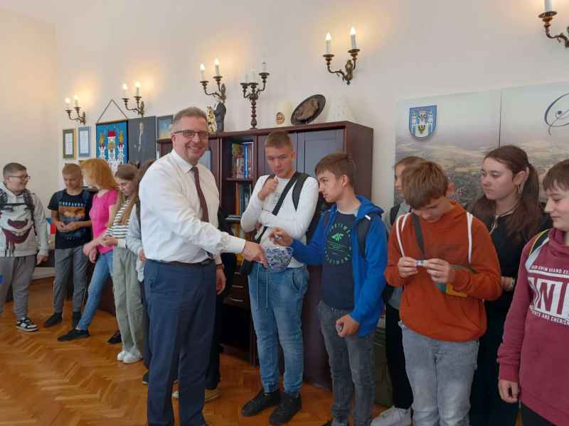 zdjęcie burmistrza częstującego młodzież cukierkami w gabinecie
