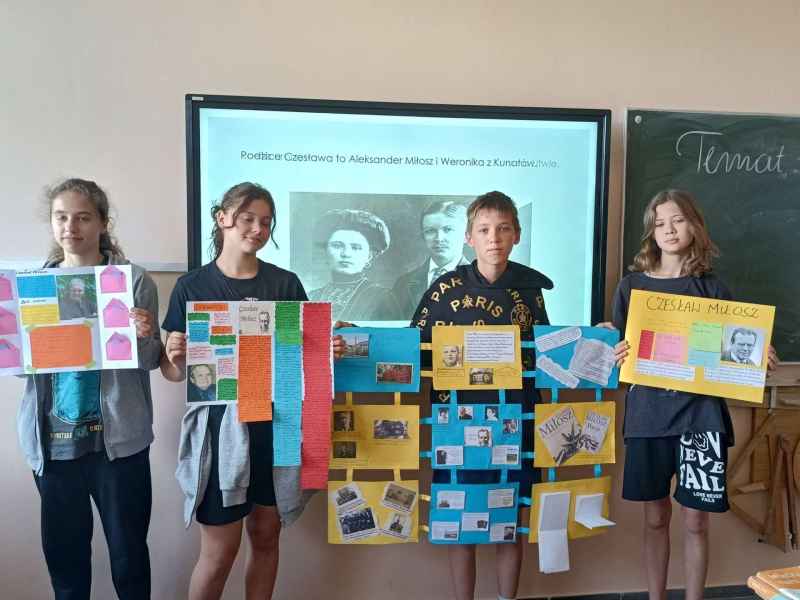 zdjęcie młodzieży w plakatami poświęconymi Czesławowi Miłoszowi