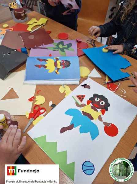 zdjęcie stołu z pracą plastyczną z kołowego origami na dole logo mFundacji i napis projekt dofinansowała Fundacja mBanku i logo biblioteki