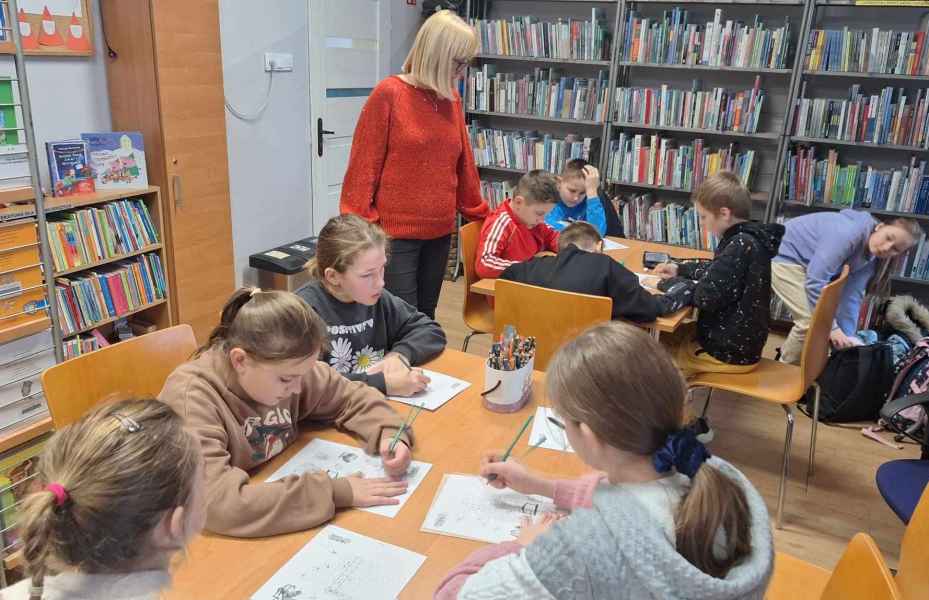 zdjęcie wychowawczyni pośród stolików z uczniami 