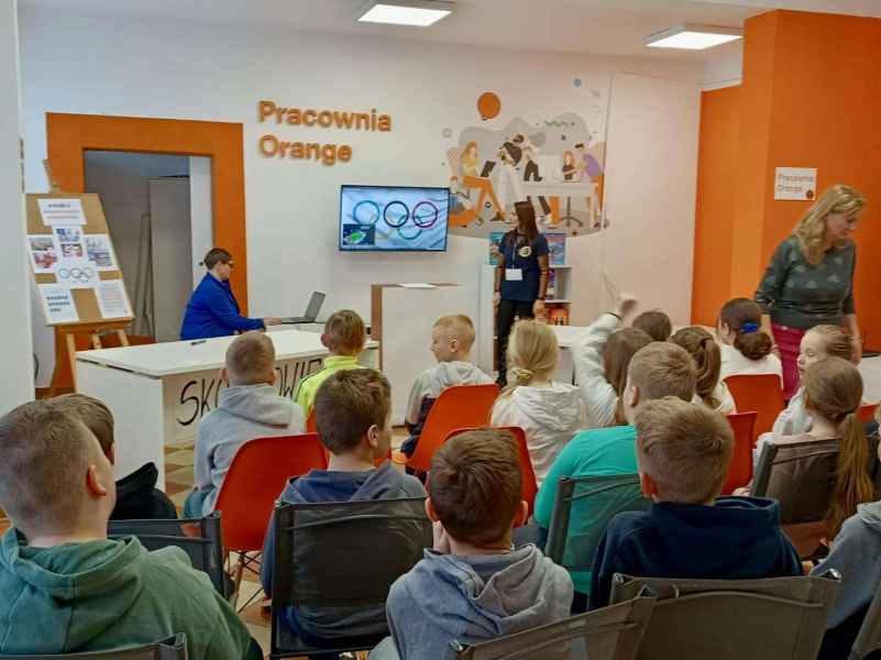 zdjęcie bibliotekarek i dzieci z nauczycielką podczas oglądania prezentacji