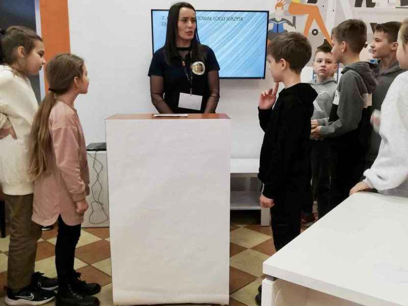 zdjęcie reprezentantów drużyn przy pulpicie z bibliotekarką