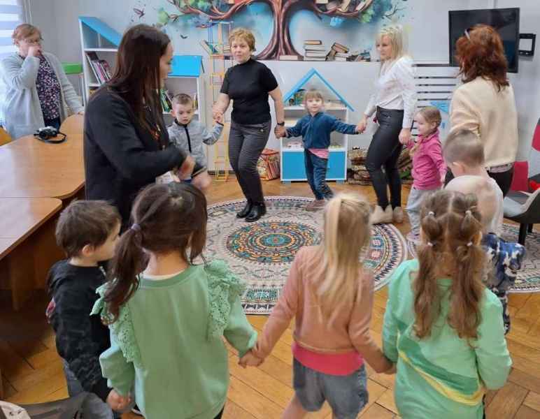 zdjęcie bibliotekarki oraz wychowawczyń z dziećmi w kółku