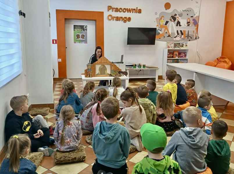 zdjęcie bibliotekarki przedstawiającej przedszkolakom teatrzyk kamishibai