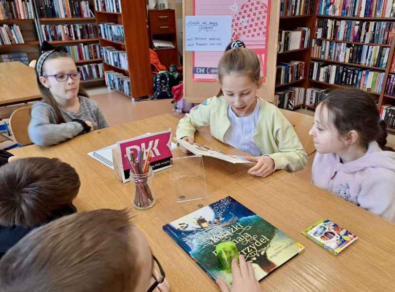 zdjęcie dzieci podczas słuchania koleżanki czytającej książkę