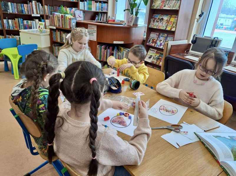 zdjęcie dzici podczas naklejania wstążek i papieru na szblon jajka