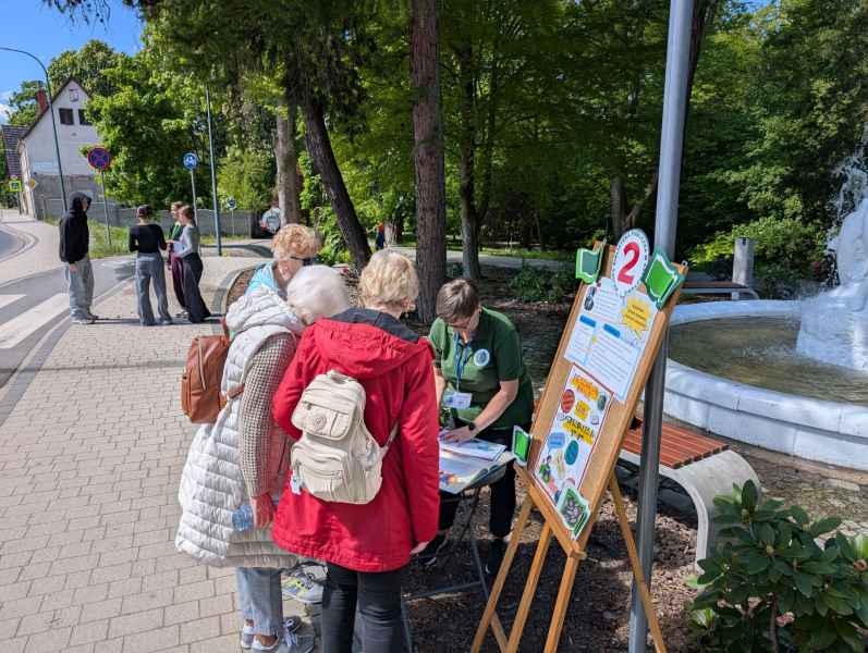 zdjęcie grupy seniorów przy stanowisku nr 3 gry miejskiej z bibliotekarką