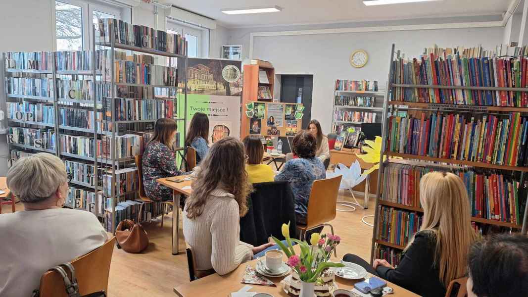 zdjęcie autorki i czytelników siedzących przy stolikach w bibliotece