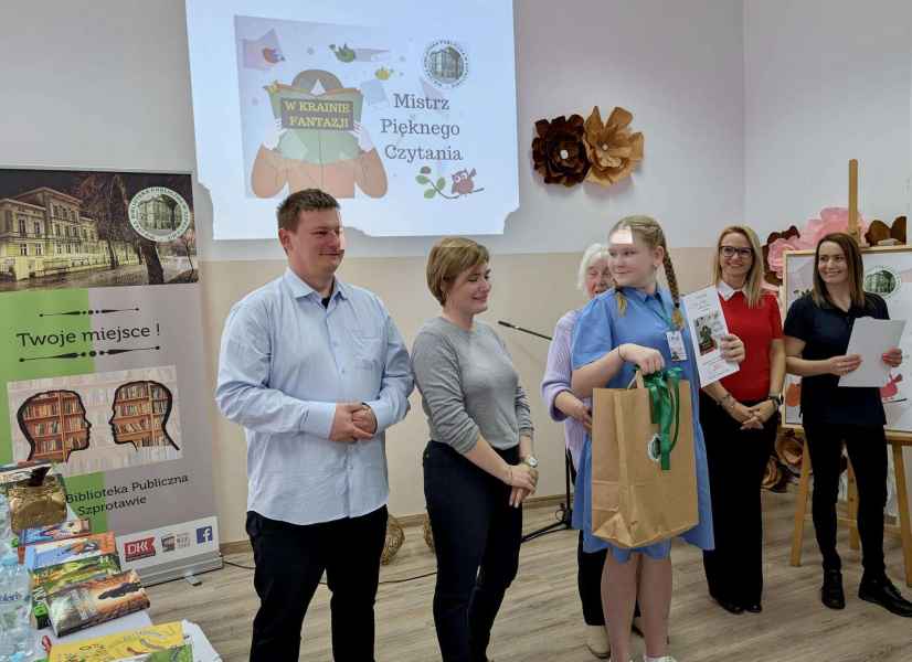 zdjęcie jury podczas wręczania nagrody dziewczynce, w tle baner biblioteki i rzut ekranu z napisem mistrz pięknego czytania